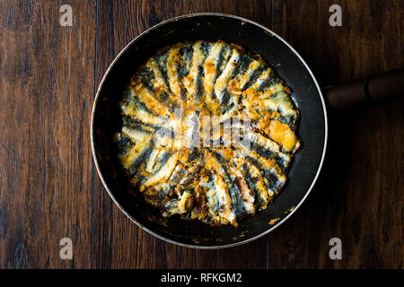 Frisch gebratene Sardinen und Sardellen Hamsi Tava in Pan auf Holz- Oberfläche. Fisch und Meeresfrüchte Stockfoto