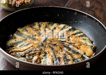 Frisch gebratene Sardinen und Sardellen Hamsi Tava in Pan auf Holz- Oberfläche. Fisch und Meeresfrüchte Stockfoto