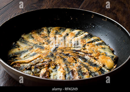 Frisch gebratene Sardinen und Sardellen Hamsi Tava in Pan auf Holz- Oberfläche. Fisch und Meeresfrüchte Stockfoto