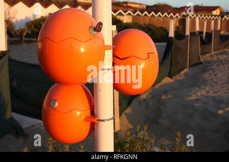 Süße orange Eier, ovale Kugeln für Mobiltelefone direkt am Meer. Akku für Smartphone am Strand. geniale Idee Stockfoto