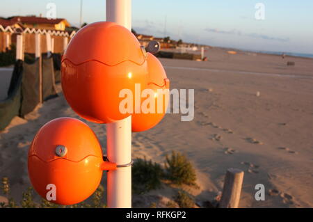 Süße orange Eier, ovale Kugeln für Mobiltelefone direkt am Meer. Akku für Smartphone am Strand. geniale Idee Stockfoto