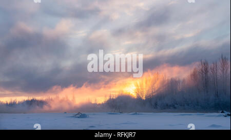Licht der untergehenden Sonne vermittelt warme Glühen zu Mist aus steigenden des Susitna River in Talkeetna in Southcentral Alaska. Stockfoto