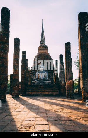 Tempelanlage in Sukhothai, Thailand. Schönen historischen Park in der Mitte von Thailand. Sitzung Statue vor der Pagode. Stockfoto