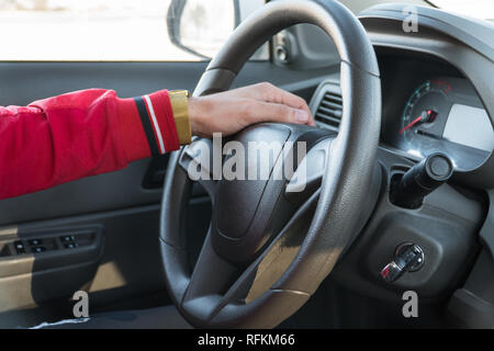 Die Männer Hand mit einer Uhr am Lenkrad eines modernen Autos Stockfoto