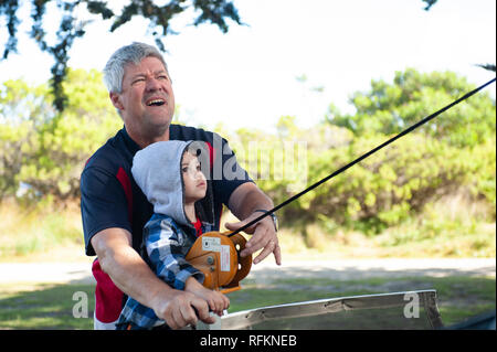 Vater und Sohn, die Winde auf ein Camper Trailer. Stockfoto