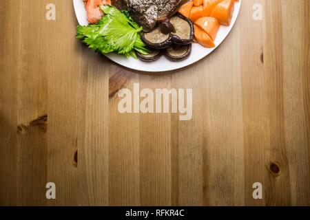Hohe Betrachtungswinkel von gegrillten Speisen mit Steak und Gemüse verteilen sich auf rustikalen Holztisch auf Grillparty nettes Foto Stockfoto
