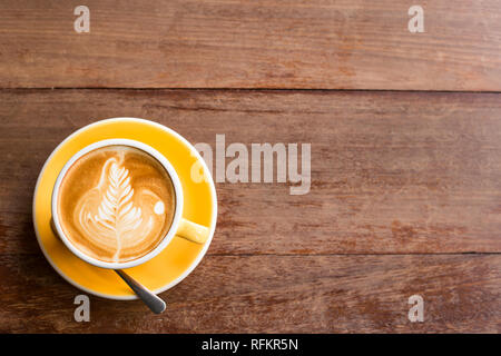 Heiße Kunst Latte Kaffee in einer Tasse auf Holztisch Stockfoto