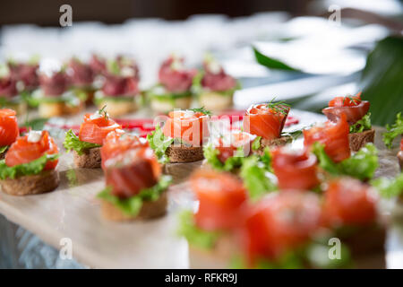 Mini Canapés mit geräuchertem Lachs mit Salat und Dill auf Buffet Tisch eingerichtet. Catering Konzept Stockfoto