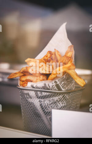 Pommes frites oder Pommes frites hinter dem Tresen, bereit zu essen. Street Food oder ungesundes Essen Konzept Stockfoto