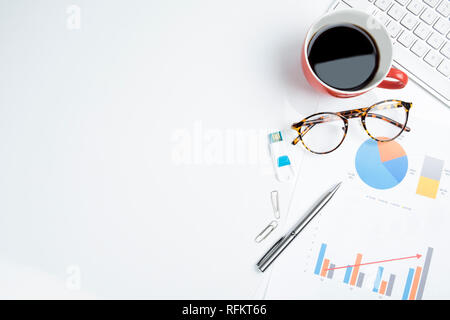 Ansicht von oben von Büromaterial und rot Tasse Kaffee auf einem weißen Tisch Hintergrund. Stockfoto