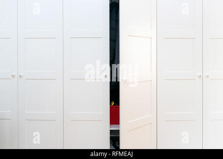 Modernes weißes Holzgehäuse im Schlafzimmer mit einer Tür geöffnet Stockfoto