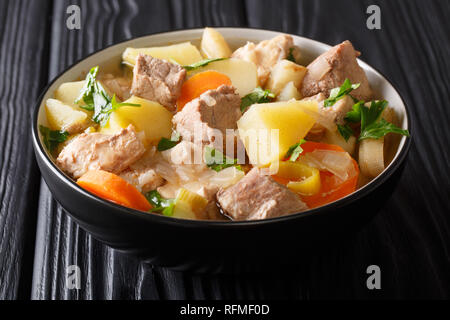 Deutsche Küche langsam gekocht Pichelsteiner mit Gemüse und Fleisch close-up in einer Schüssel auf einem Holztisch. Horizontale Stockfoto