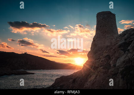 Alte steinerne Turm im La Pietra in Ile Rousse in der Balagne Korsika durch einen dramatischen Sonnenuntergang über dem Mittelmeer ab s Stockfoto