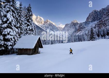 Winter im Freien können Märchen, für Kinder, junge Wandern im Schnee zu einem Chalet aus Holz, Berge im Licht im Hintergrund die Julischen Alpen Stockfoto