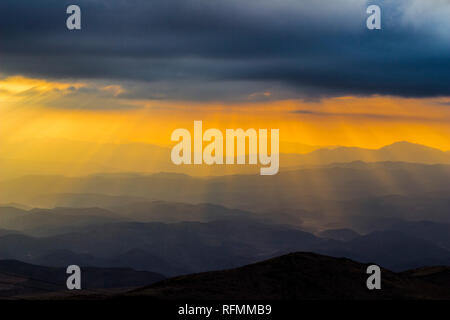 Sonnenuntergang bei 'La Silla" Sternwarte, ein Blick über den Horizont mit dem Strahl des Lichtes aus der Sonne durch die Wolken lagen über die Berge Stockfoto