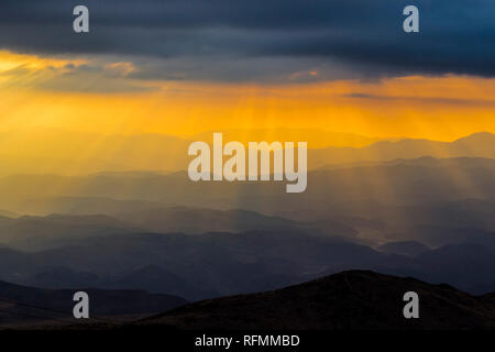 Sonnenuntergang bei 'La Silla" Sternwarte, ein Blick über den Horizont mit dem Strahl des Lichtes aus der Sonne durch die Wolken lagen über die Berge Stockfoto