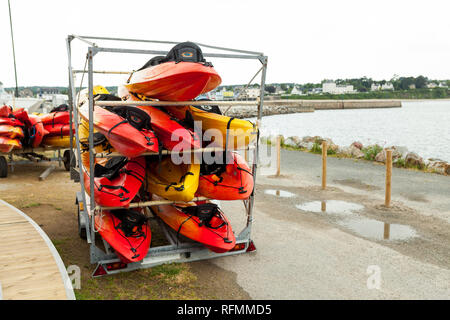 Im Sonnenlicht, Rot, Gelb und Weiß Kajaks platziert mit der Oberseite nach unten auf Metall Lagerregale. Gefüllte Kanu in Brest, Frankreich, 28. Mai 2018. Stockfoto