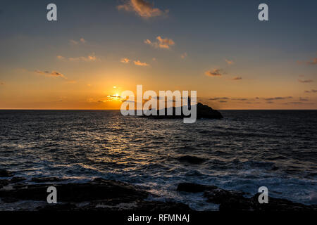 Goldenen Sonnenuntergang am Meer bei Godrevy Leuchtturm mit blauem Himmel und Wolken Godrevy West Cornwall UK Europa shining Stockfoto