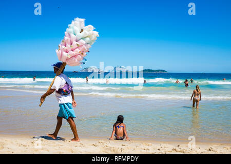 RIO DE JANEIRO - Februar, 2018: Eine junge brasilianische Hersteller Spaziergänge verkaufen Baumwolle Zuckerwatte entlang dem Ufer von Ipanema Beach. Stockfoto