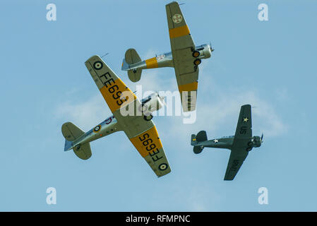 Nordamerikanische T-6 Texan, Harvard-Trio bricht an Land. Im Zweiten Weltkrieg wurden Kampfpiloten ausgebildet. Fliegen bei der Flugschau Stockfoto