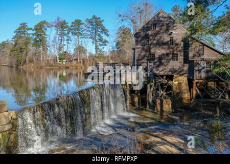 Malerische Winter Blick auf den Wasserfall und den Damm durch die alte Mühle an der historischen Mühle Yates County Park in Raleigh, North Carolina. Eiszapfen Hand aus der f Stockfoto