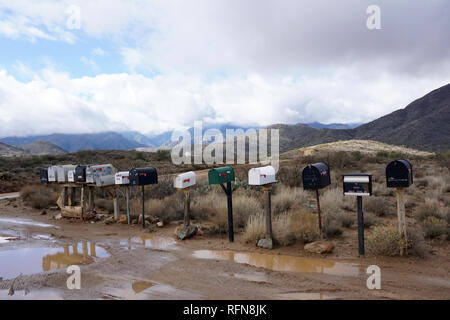 Eine Reihe von Postfächern aus einer ersten Straße mitten in der Wüste nach einem Regensturm weitergegeben. Stockfoto