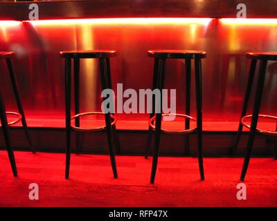 Barhocker in einer Bar, rotes Licht Design Stockfoto