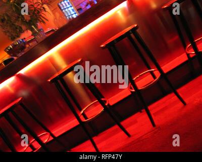 Barhocker in einer Bar, rotes Licht Design Stockfoto