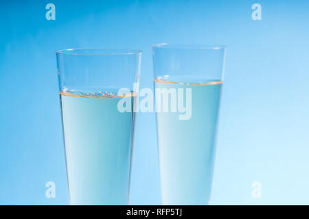 Nahaufnahme von zwei Gläser Champagner auf einem blauen Hintergrund Stockfoto