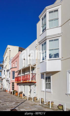 Georgische Häuser in Grand Parade, Portsmouth, Hampshire, Großbritannien, darunter auch Reihenhäuser mit rosa Schleife mit Glasfassade, Fenster und roten schmiedeeisernen Balkon Stockfoto