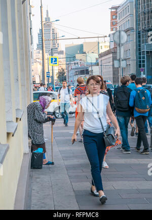 Moskau, Russland - September 6, 2018: Ältere Frau bittet um Almosen von Passanten auf der Straße. Rentner ständigen beugte sich mit einem Stock Kreuz selbst und Stockfoto