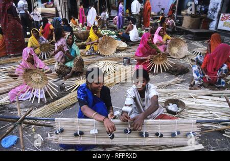 Die Frauen weben Korbmacherwaren auf einem Markt, Udaipur, Indien Stockfoto
