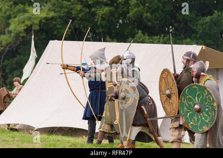 Mittelalterliche Re-enactors in Rüstung und Kostüme des 12. Jahrhunderts mit Bögen Schwerter und Schilde ausgestattete gekleidet nachgespielt Bekämpfung des Zeitraums Stockfoto