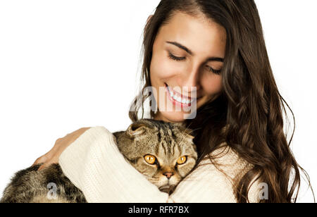 Schönes helles zartes Mädchen in einem weißen Pullover mit einer Katze auf dem Arm auf einem weißen Hintergrund isoliert. Konzept der Beziehung mit tierischen Stockfoto