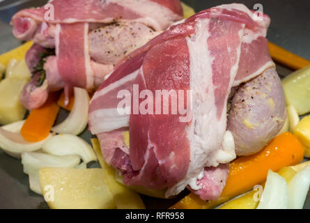 In der Nähe von zwei Ungekocht poussin in durchwachsener Speck gewickelt auf dem Bett von Gemüse bereit für Braten im Ofen Stockfoto