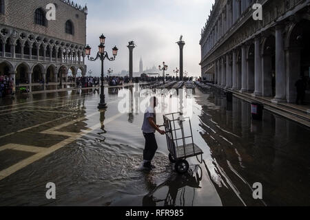 San Marco Platz, Piazza San Marco, mit einem Arbeiter treibt einen Wagen, während der Acqua Alta überflutet Stockfoto