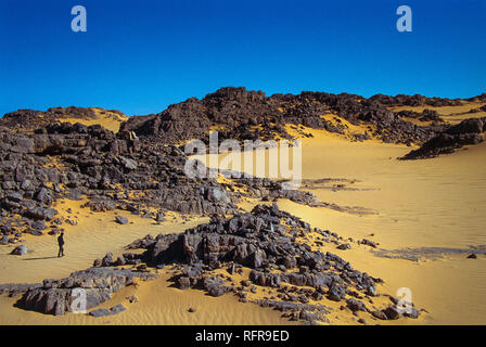 TASSILI N'Ajjer, ALGERIEN - Januar 10, 2002: unbekannter Mann Spaziergänge in den Dünen der algerischen Sahara, Afrika, Tassili N'Ajjer Nationalpark Stockfoto