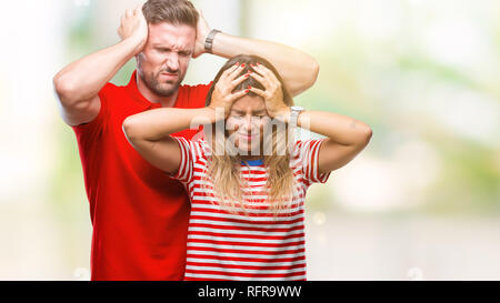 Junge Paare, die in Liebe über isolierte Hintergrund Kopfschmerzen leiden, verzweifelte und betonte, weil Schmerz und Migräne. Hände auf den Kopf. Stockfoto