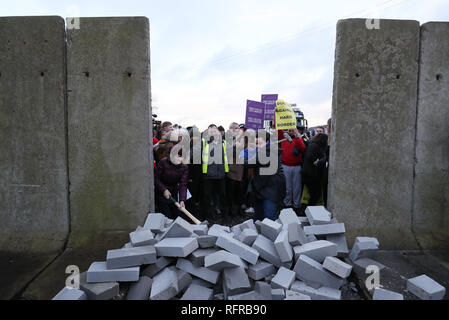 Die Demonstranten knock down eine symbolische Mauer, die als Teil einer anti-Brexit Kundgebung an der irischen Grenze in der Nähe von Carrickcarnan, Co Louth gebaut wurde. Stockfoto