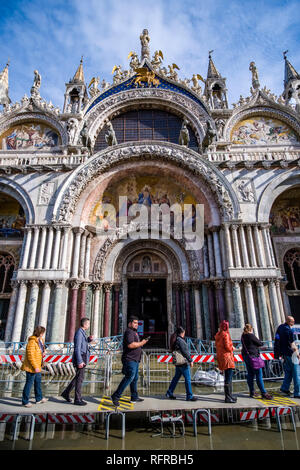 Viele Touristen sind zu Fuß auf Stegen vor Saint Mark's Basilika, der Basilika di San Marco, San Marco Platz, der Piazza San Marco während t überschwemmt Stockfoto