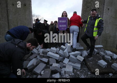 Die Demonstranten knock down eine symbolische Mauer, die als Teil einer anti-Brexit Kundgebung an der irischen Grenze in der Nähe von Carrickcarnan, Co Louth gebaut wurde. Stockfoto