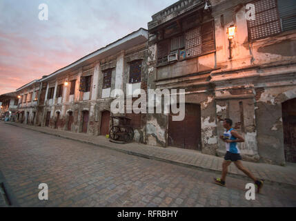 Jogger auf historischen gepflasterten Calle Crisologo, Vigan, Ilocos Sur, Philippinen Stockfoto