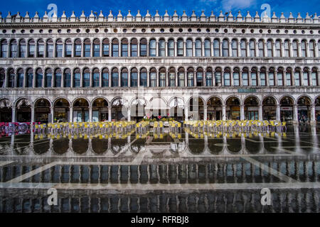 San Marco Platz, Piazza San Marco, mit Tischen und Stühlen für ein Restaurant vor der Procuratie Vecchie, während der Acqua Alta überflutet Stockfoto