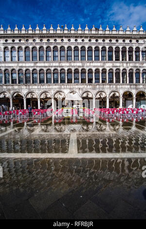 San Marco Platz, Piazza San Marco, mit Tischen und Stühlen für ein Restaurant vor der Procuratie Vecchie, während der Acqua Alta überflutet Stockfoto