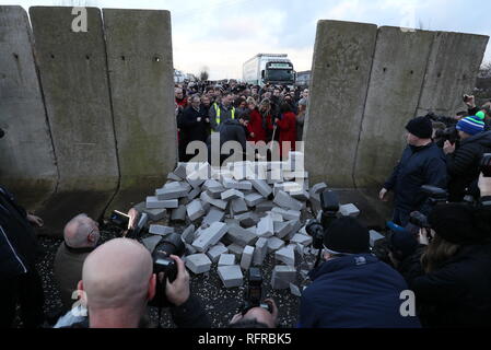 Die Demonstranten knock down eine symbolische Mauer, die als Teil einer anti-Brexit Kundgebung an der irischen Grenze in der Nähe von Carrickcarnan, Co Louth gebaut wurde. Stockfoto