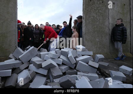 Die Demonstranten knock down eine symbolische Mauer, die als Teil einer anti-Brexit Kundgebung an der irischen Grenze in der Nähe von Carrickcarnan, Co Louth gebaut wurde. Stockfoto