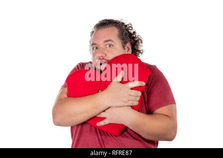 Ein studio geschossen von einem fetten Mann hält eine rote herzförmige Kissen isoliert Stockfoto