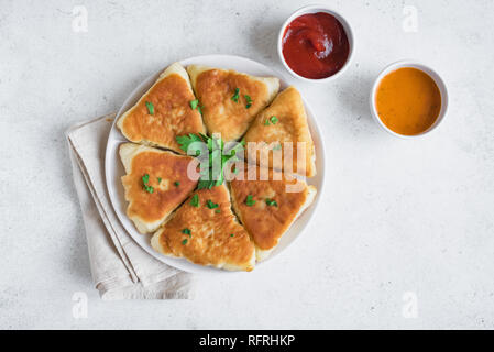 Frittierte vegetarische vegane Torten mit Soßen, samsa, Samosas - traditionelle Gemüse gefüllte Pasteten, vegetarische Pasteten mit Soßen auf weißem Hintergrund, Co Stockfoto