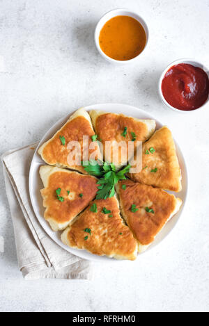 Frittierte vegetarische vegane Torten mit Soßen, samsa, Samosas - traditionelle Gemüse gefüllte Pasteten, vegetarische Pasteten mit Soßen auf weißem Hintergrund, Co Stockfoto