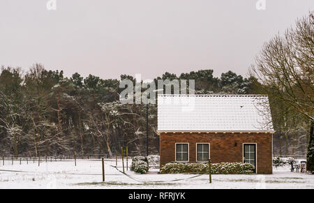 Kleinbauern Cottage in einer Winterlandschaft Landschaft, Feldern und Haus mit Schnee bedeckt, Leben in der Nähe der Wald Stockfoto